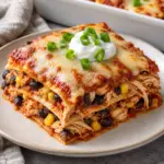 A square recipe image of chicken enchilada casserole with golden Monterey Jack