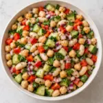 Dense bean salad with chickpeas and cannellini beans on a cream plate