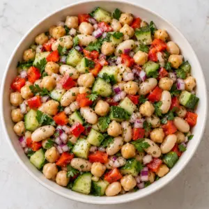 Dense bean salad with chickpeas and cannellini beans on a cream plate