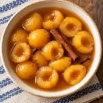 Dulce de tejocote served in a bowl with cinnamon-piloncillo syrup.