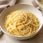 Frozen lemon pasta with Parmesan and black pepper in a shallow bowl