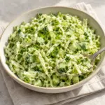 Spoonful of green goddess cabbage salad showing crisp cabbage and cucumber in creamy dressing