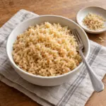 How to cook brown rice: a white bowl of tender tan grains