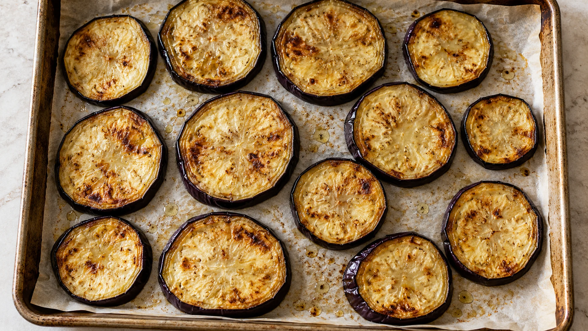 Roasted eggplant rounds on a baking tray for moussaka